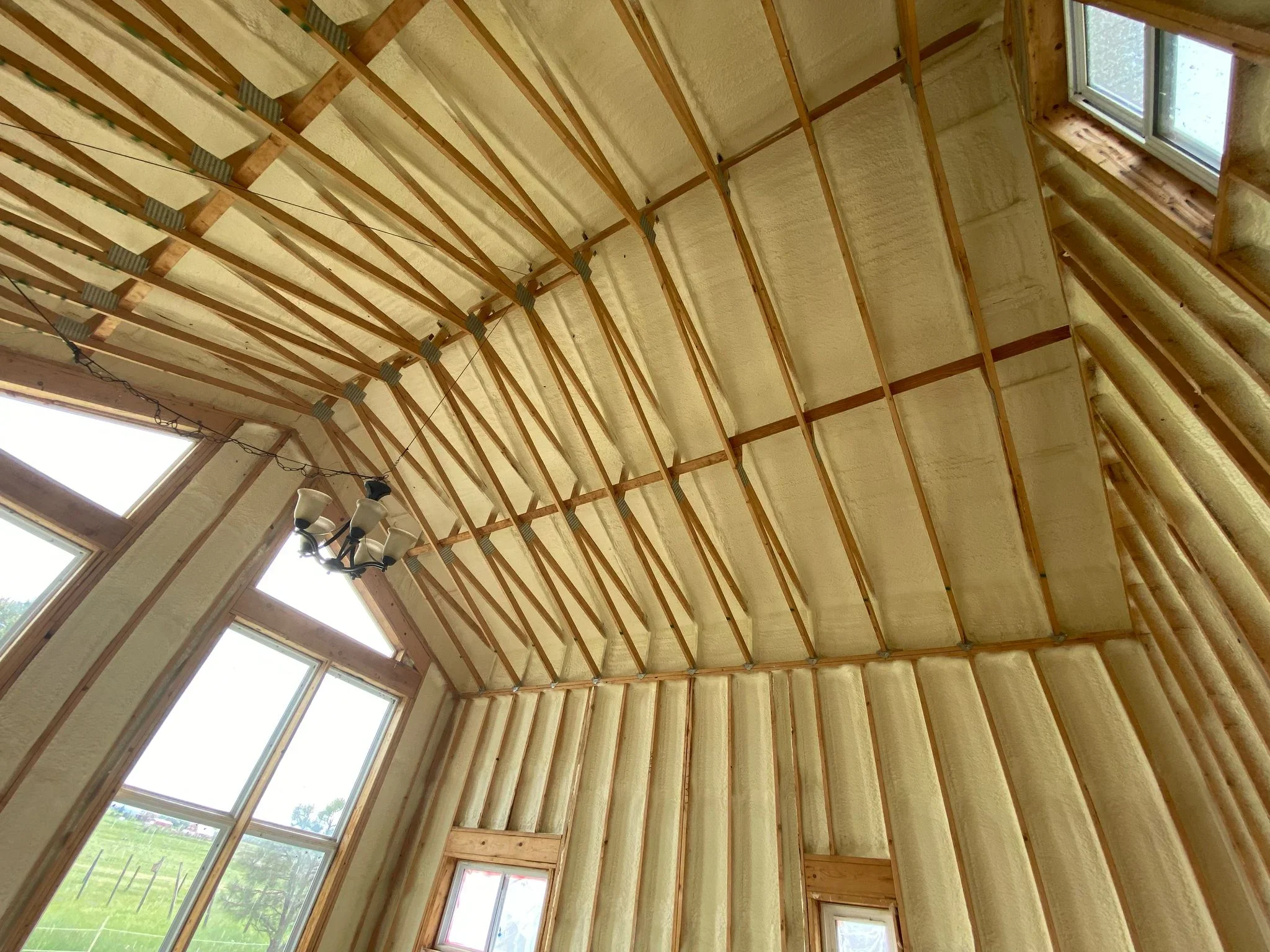 Vaulted ceiling with fiberglass insulation batts installed between wood rafters and framing