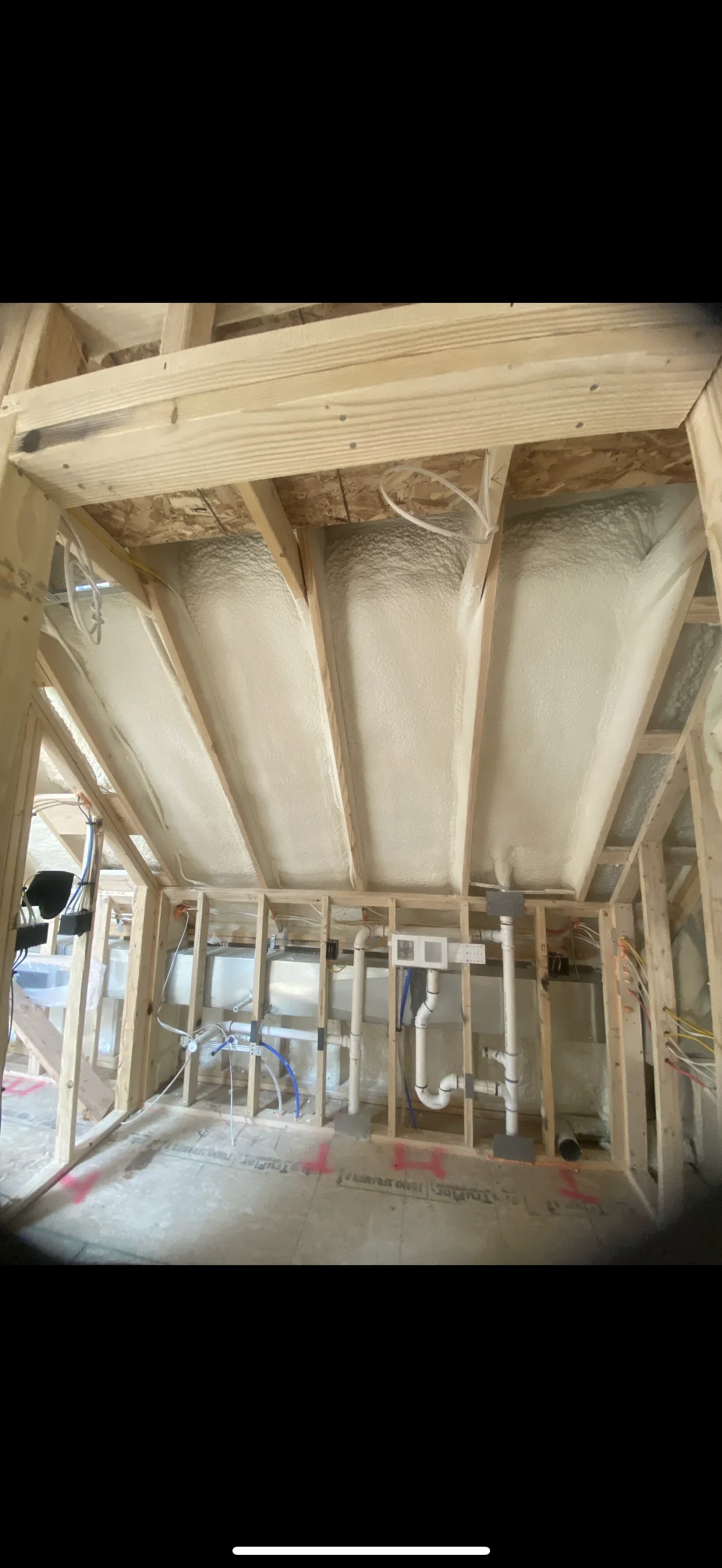 Fiberglass batt insulation installed between wooden joists in attic with HVAC ducts