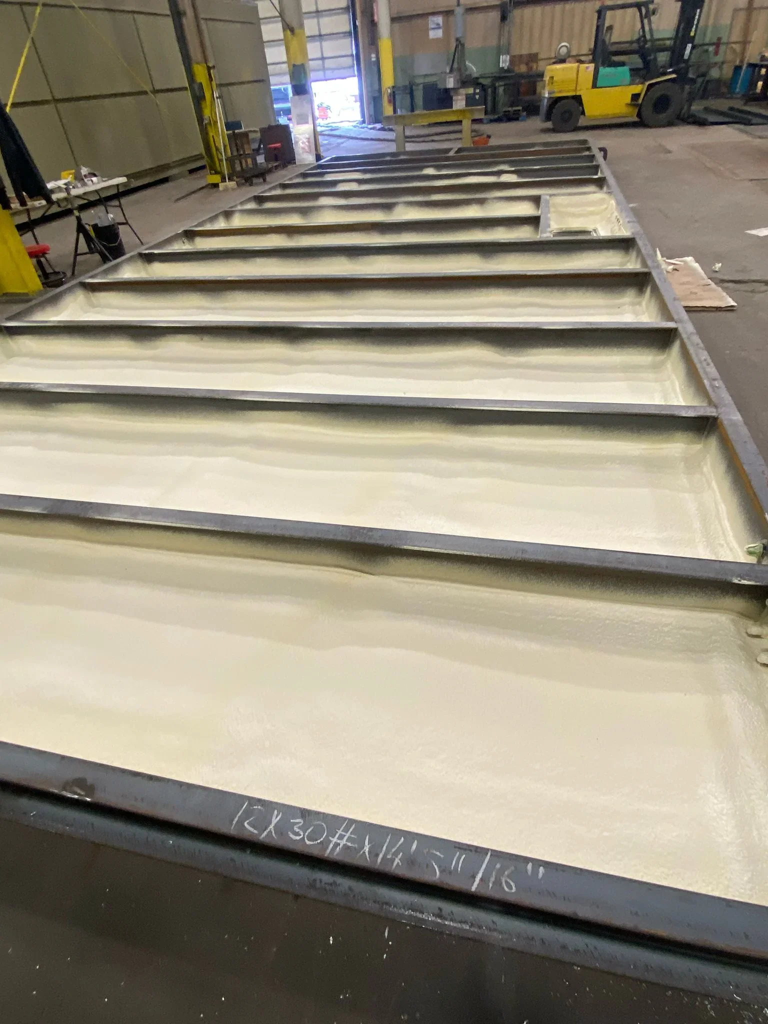 Fiberglass batt insulation installed between steel support channels in commercial warehouse